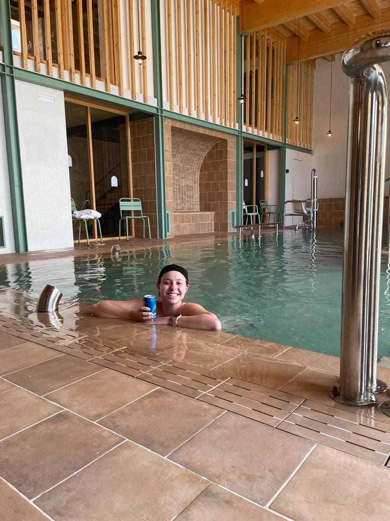 Smiling woman in a pool with a drink in Hontanas Spain