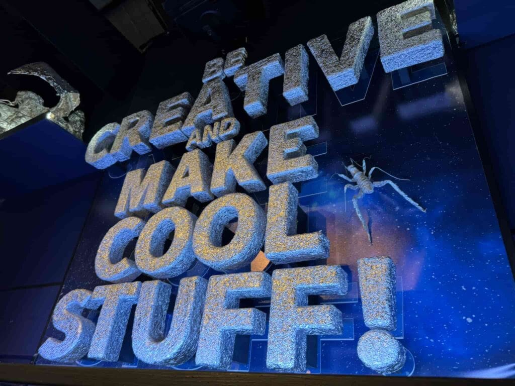 Foil art display at Wētā Workshop Wellington that says, "Be Creative and Make Cool Stuff!"