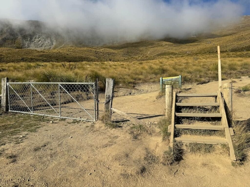 Set of steps going over one of the cattle gates on the Roy's Peak Track.