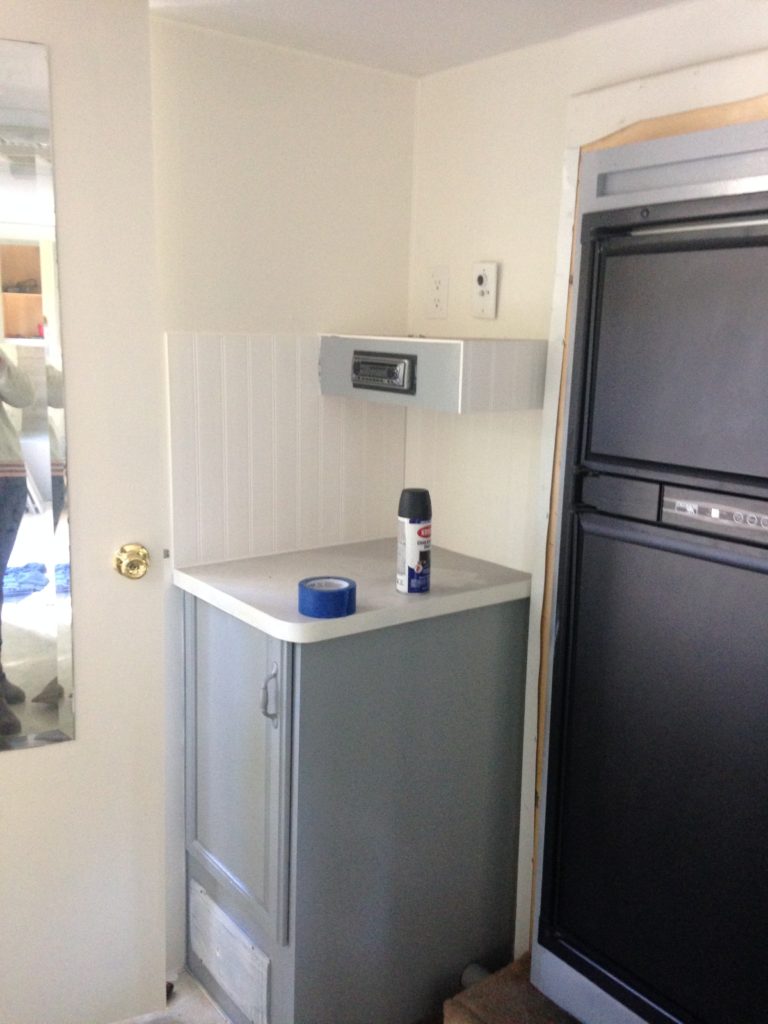 picture of our RV kitchen after painting the fridge and walls. Camper remodel before and after