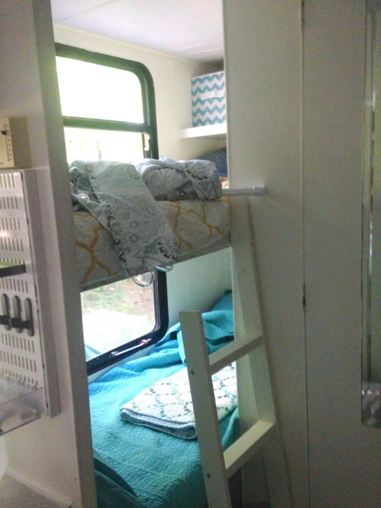 picture of our RV bunk area after painting walls and adding bedding. Camper remodel before and after