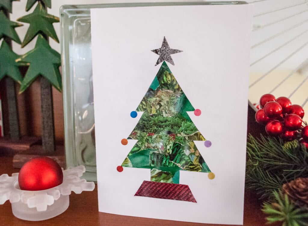 cutting an old Christmas card in the shape of a tree for a new card