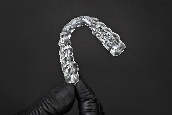 Hand holding a clear  dental splint printed with the Rapid Shape PRO 20 and RS Crystal Polish