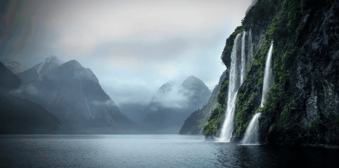 A waterfall in the middle of a mountain in new zealand.