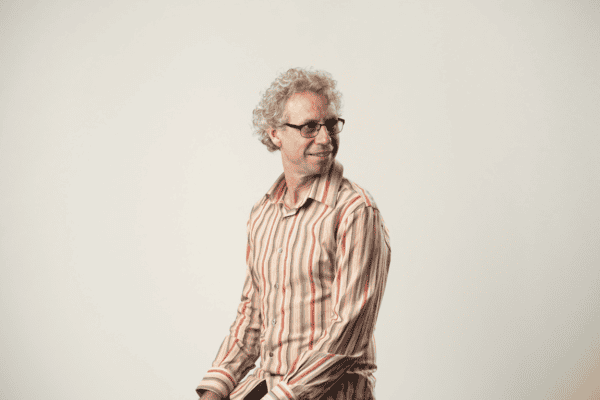 A man in a striped shirt is posing for a photo.