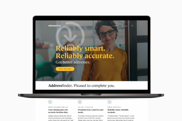 A laptop with a website home page that features woman's face for AddressFinder's brand refresh.