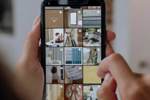 A person is holding a smartphone displaying an Instagram profile for A Beautiful Day brand with a grid of various home decor-related posts.