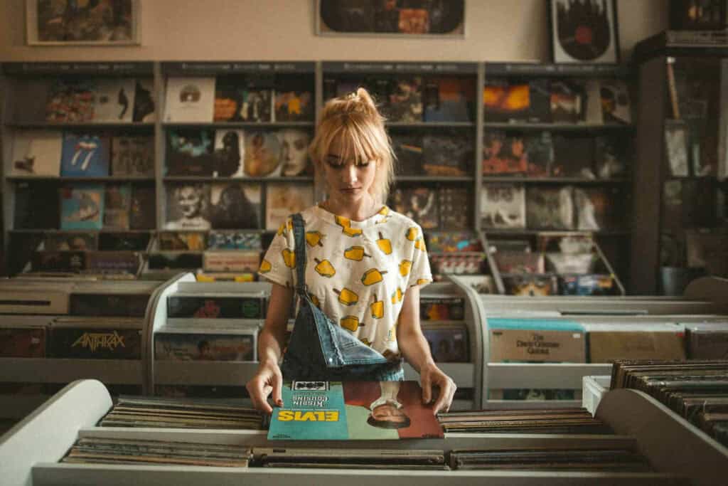 Une femme consulte la pochette d'un disque vinyle chez un disquaire. Cohérence identitaire.
