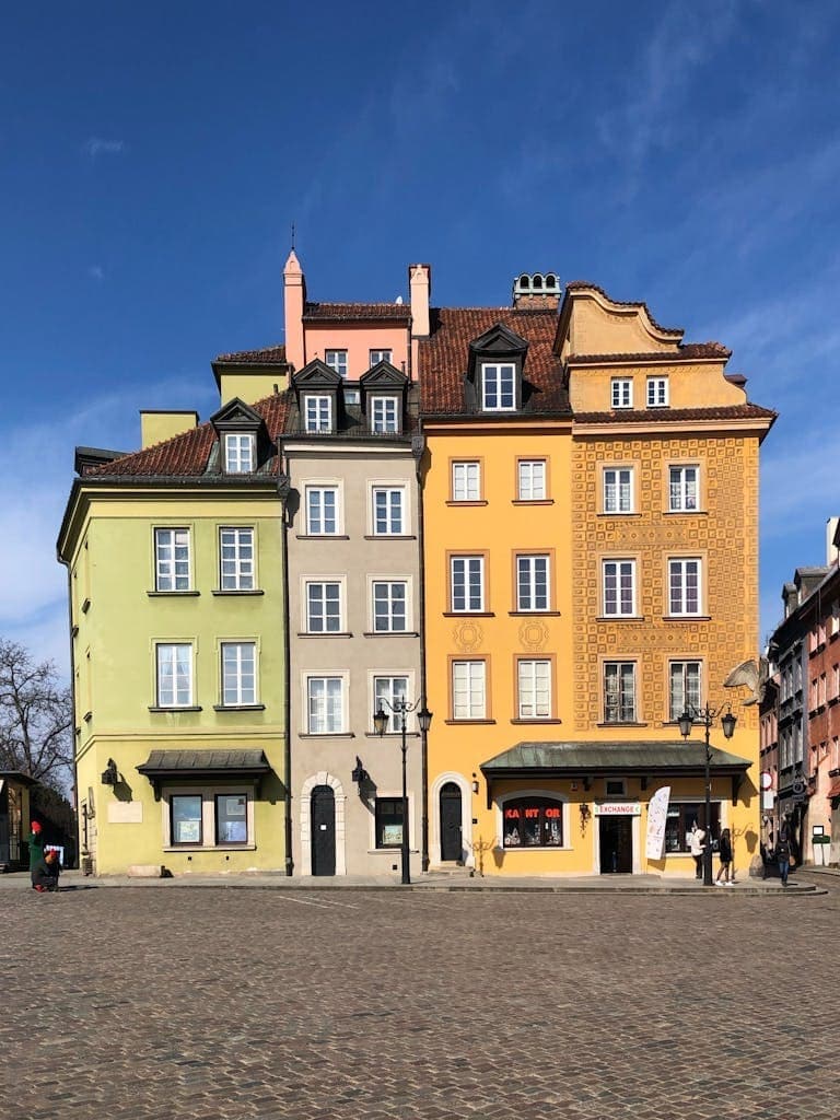 People Walking Near Yellow Concrete Building