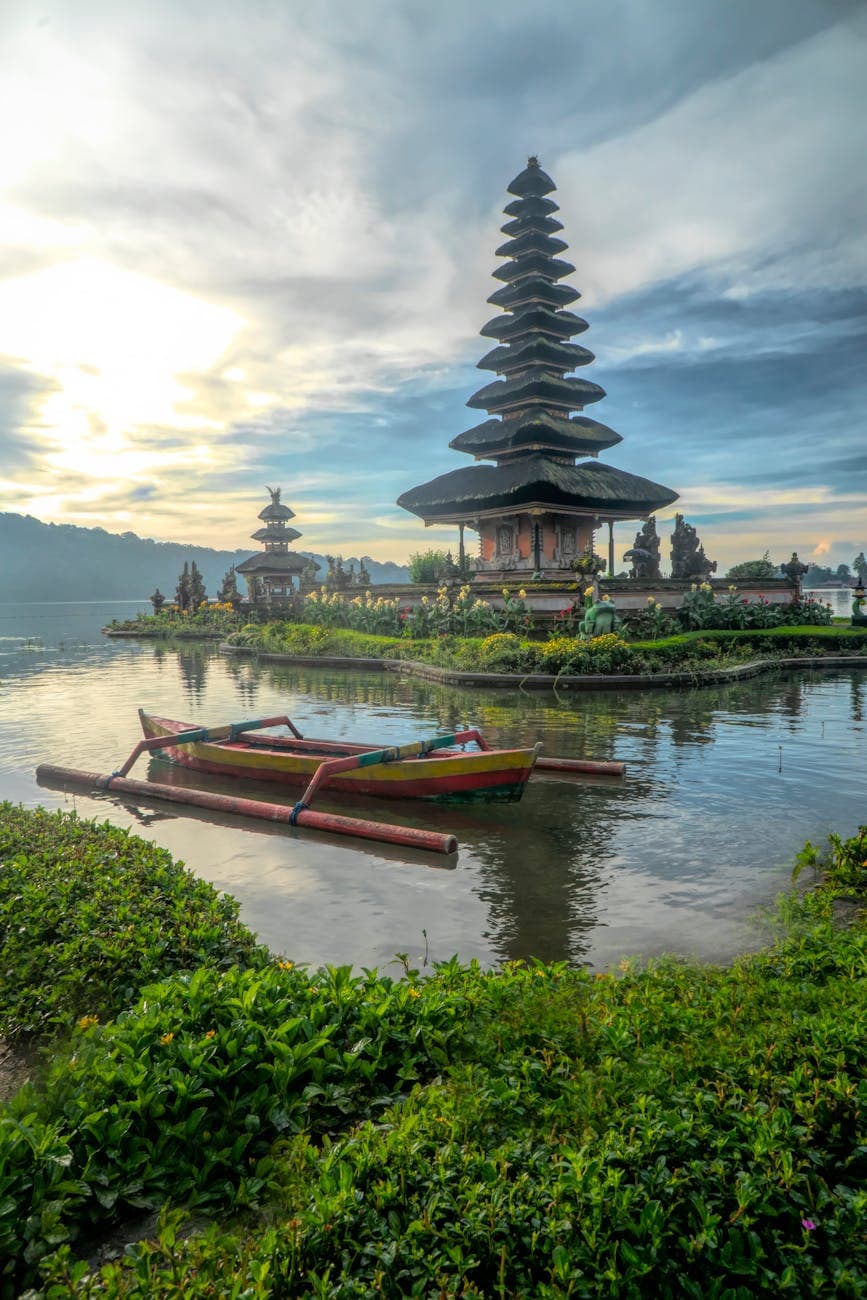 canoe on body of water with pagoda background