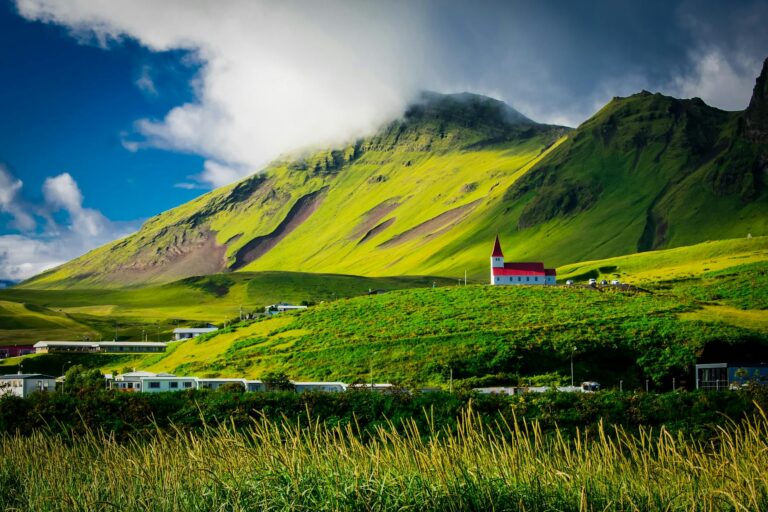 green field near mountain during daytime