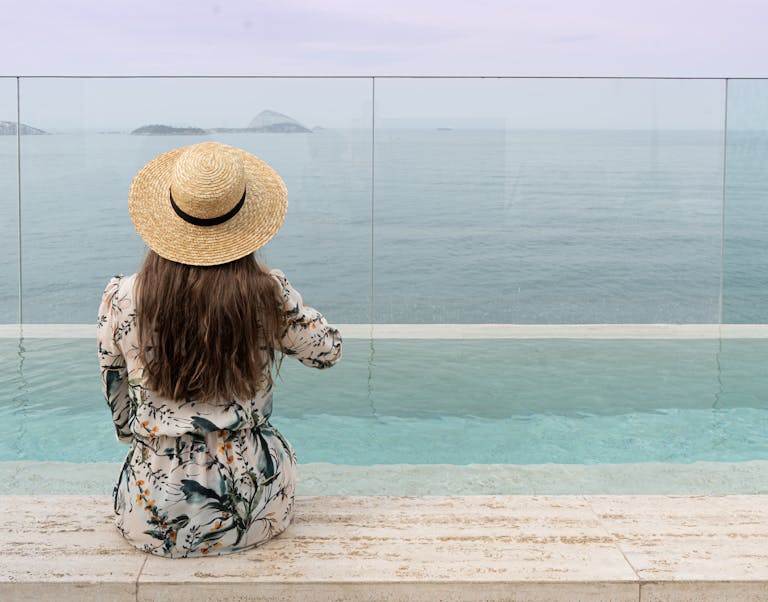 Woman Sits Oceanside with a Stunning View