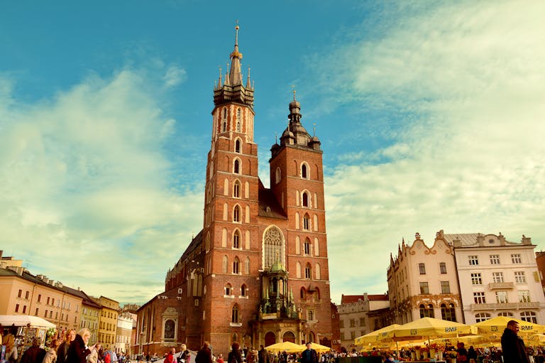 Vibrant view of St. Mary's Basilica in Krakow's bustling main square.