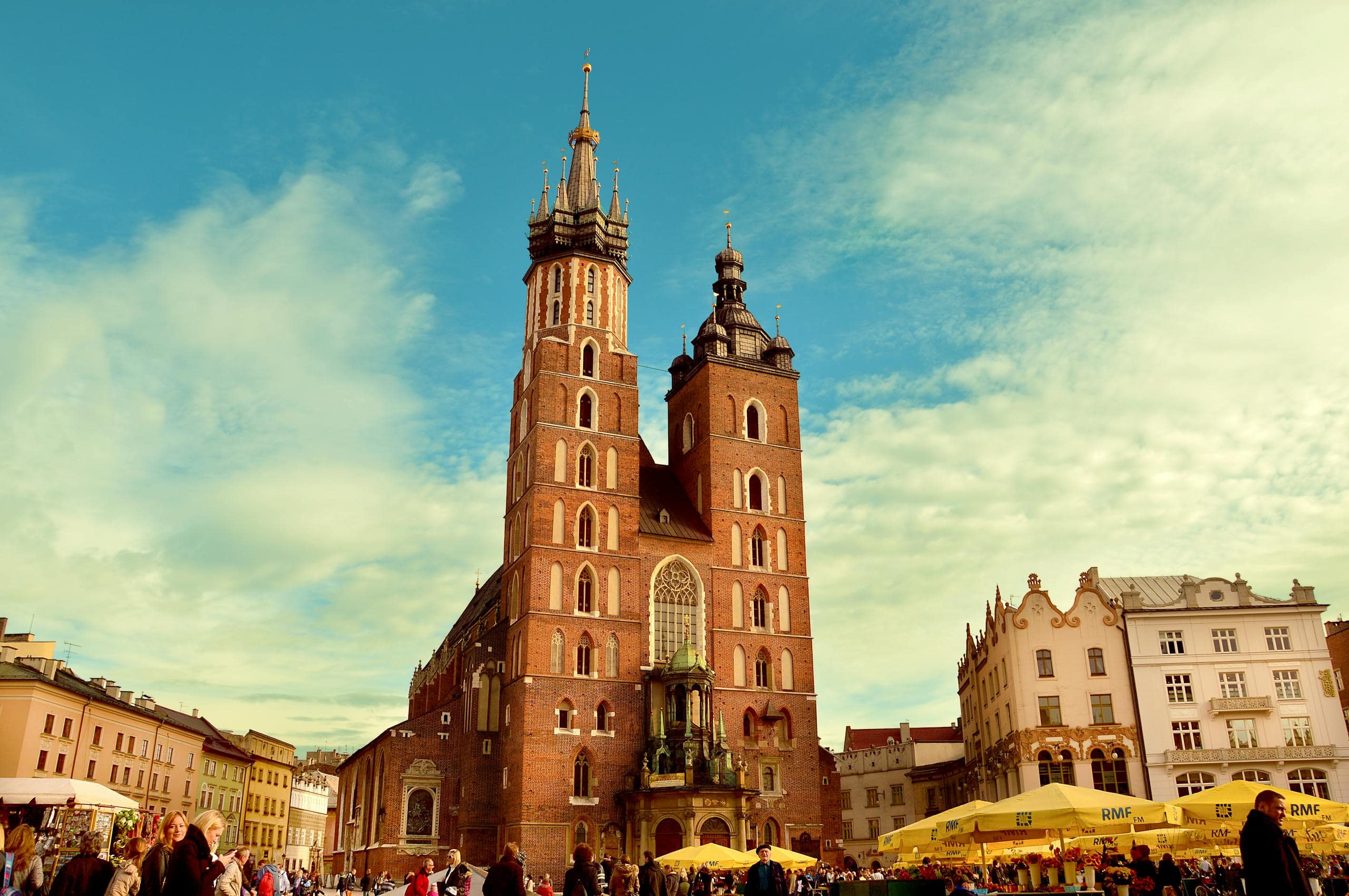 Vibrant view of St. Mary's Basilica in Krakow's bustling main square.