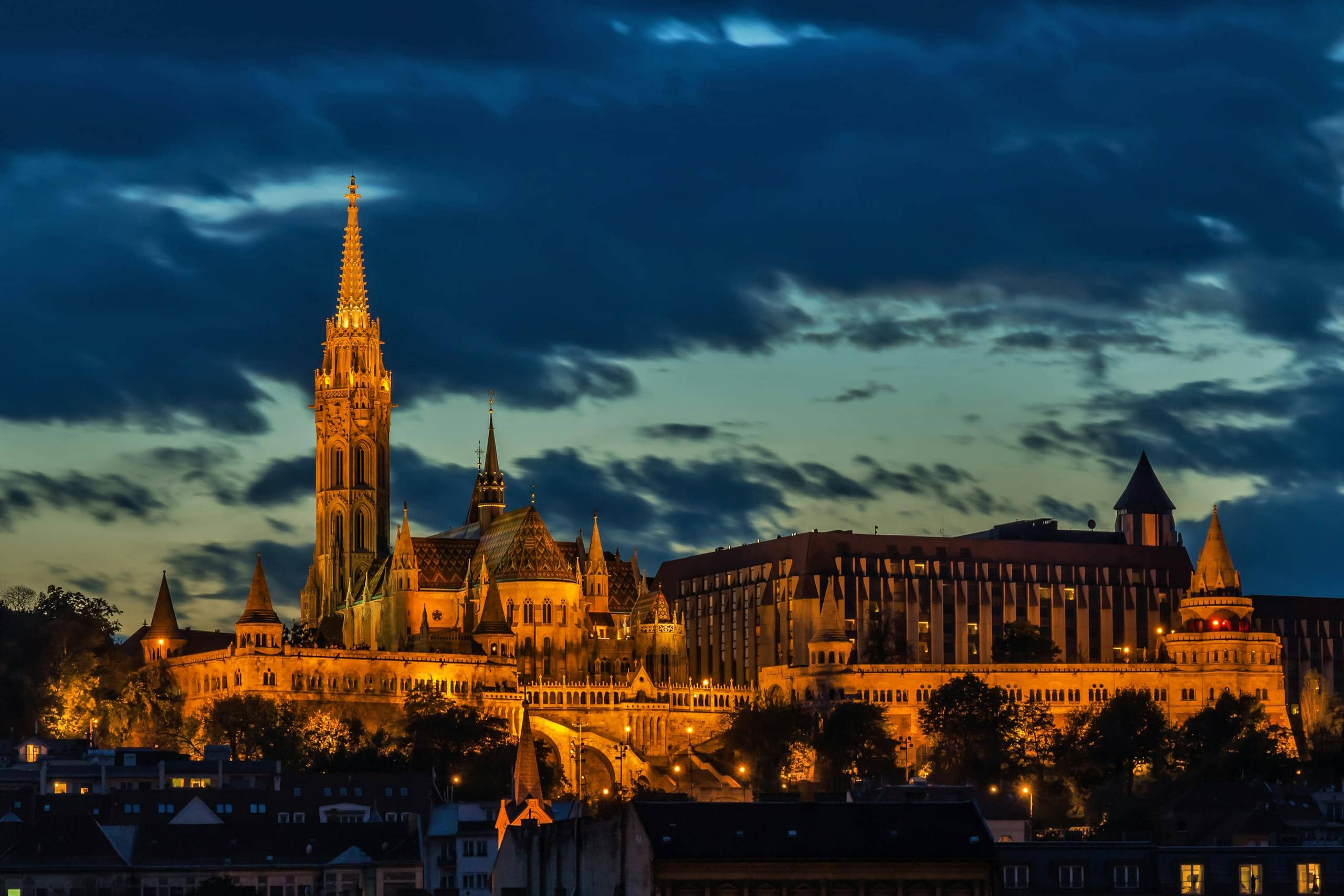 Captivating view of Matthias Church lit up at night in Budapest, Hungary. A stunning architectural marvel.