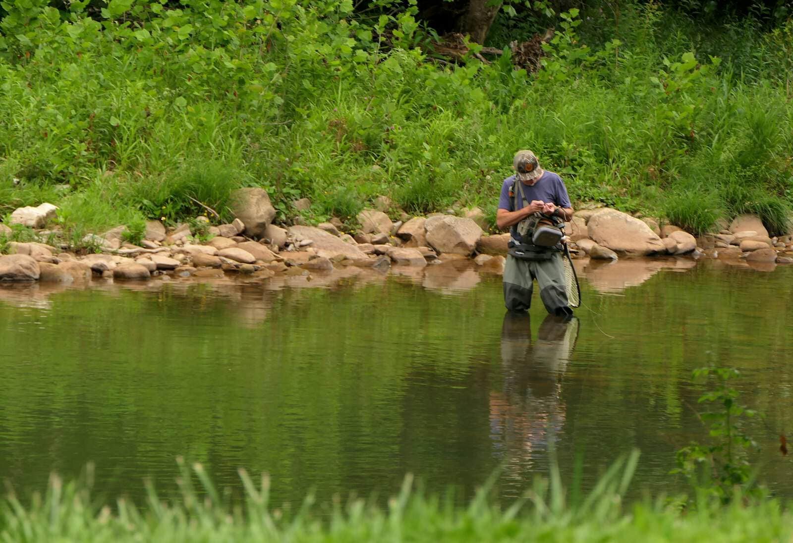 Reflection of an angler on water, for the first-hour plan on new water