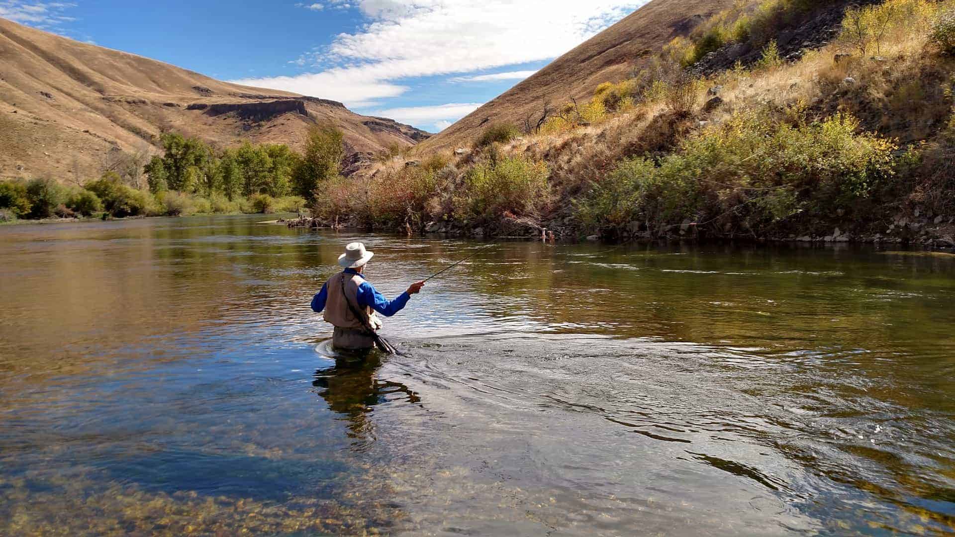Angler wading in the South Fork Boise River while fly fishing