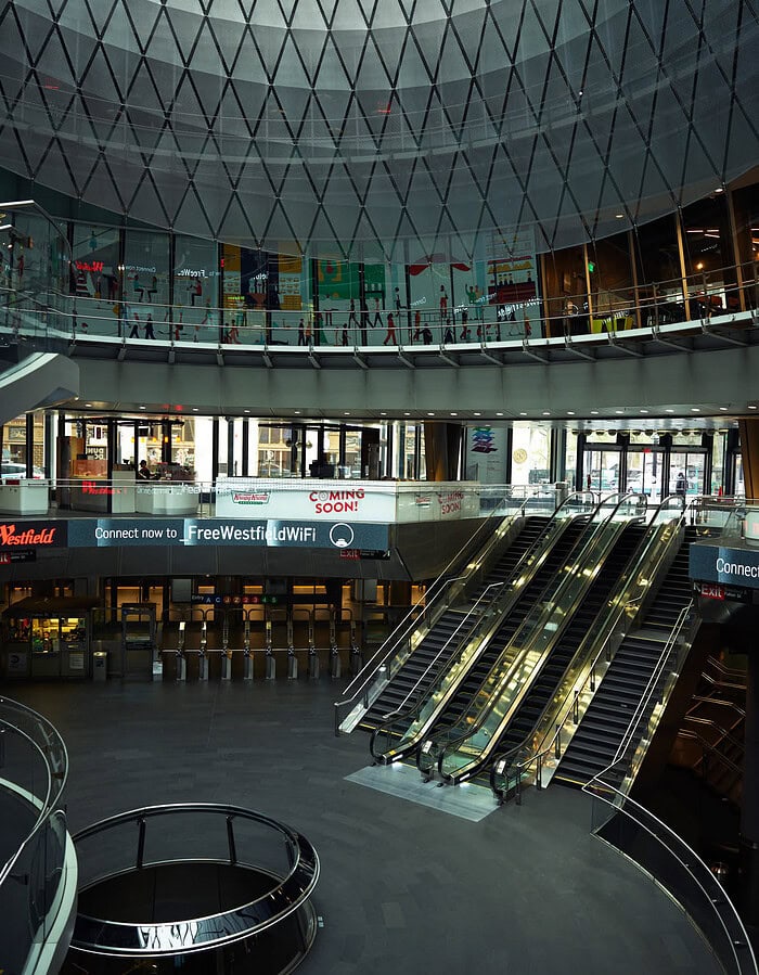 Empty escalators and glass interior inside the Westfield Oculus transit and shopping complex during COVID.