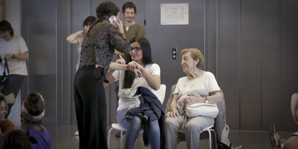 Imagen de un taller de belleza donde una profesional atiende a una mujer mayor en un entorno de aprendizaje y cuidado personal, promoviendo bienestar y atención especializada.