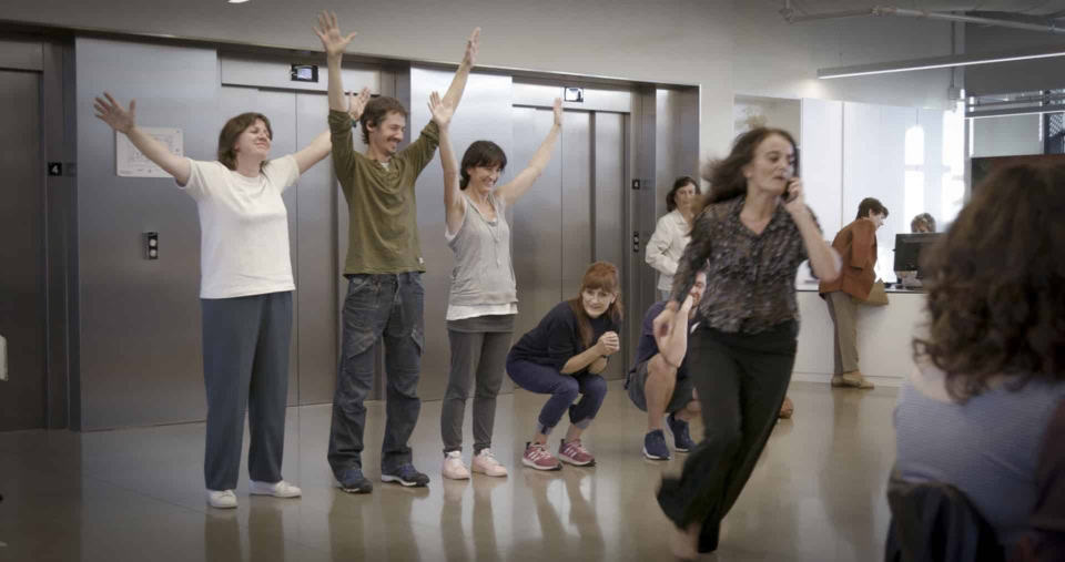 Imagen que muestra un grupo diverso de personas en un entorno laboral, participando en una actividad de team building o dinámica de grupo, promoviendo inclusión y colaboración.