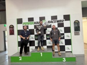 Water Tight Canberra go-kart competition winners on the podium holding trophies and medals