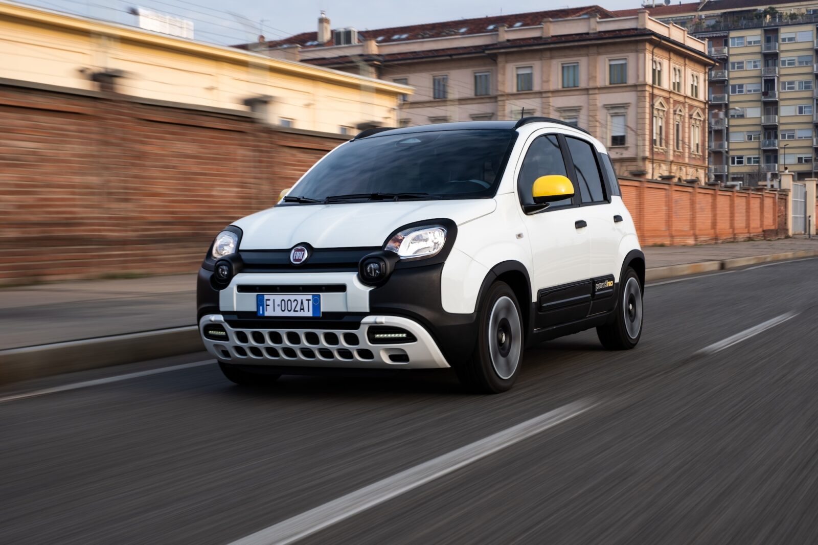Fiat Pandina 2025 Panda in movimento su strada urbana, in livrea bianca con specchietti gialli.