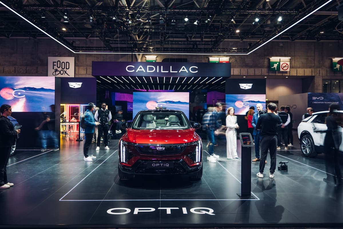 Cadillac Optiq in esposizione al salone auto con stand illuminato e pubblico