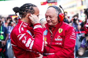 Lewis Hamilton e Frédéric Vasseur in tuta e divisa Ferrari F1 a bordo pista durante un weekend di gara.