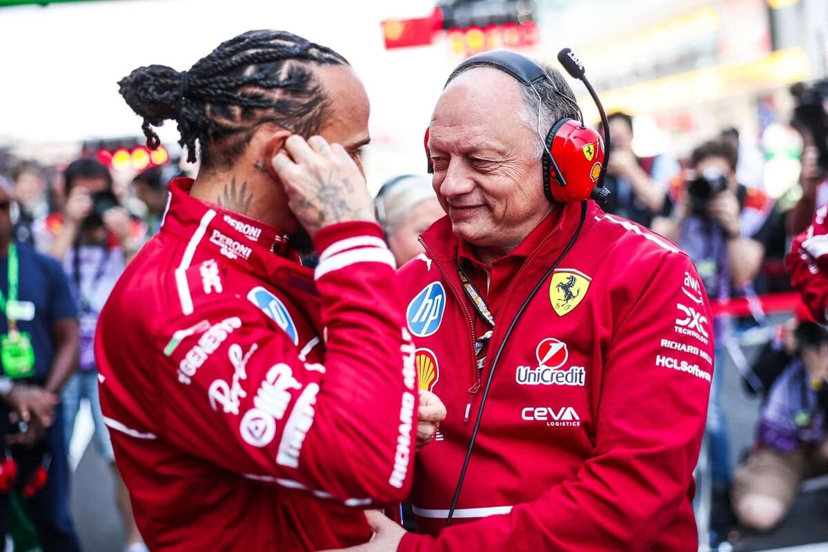Lewis Hamilton e Frédéric Vasseur in tuta e divisa Ferrari F1 a bordo pista durante un weekend di gara.