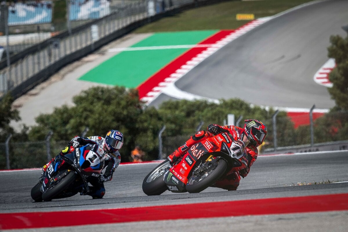 Nicolò Bulega su Dicati davanti a Toprak Razgatlioglu su BMW in curva durante una gara di SBK 2025