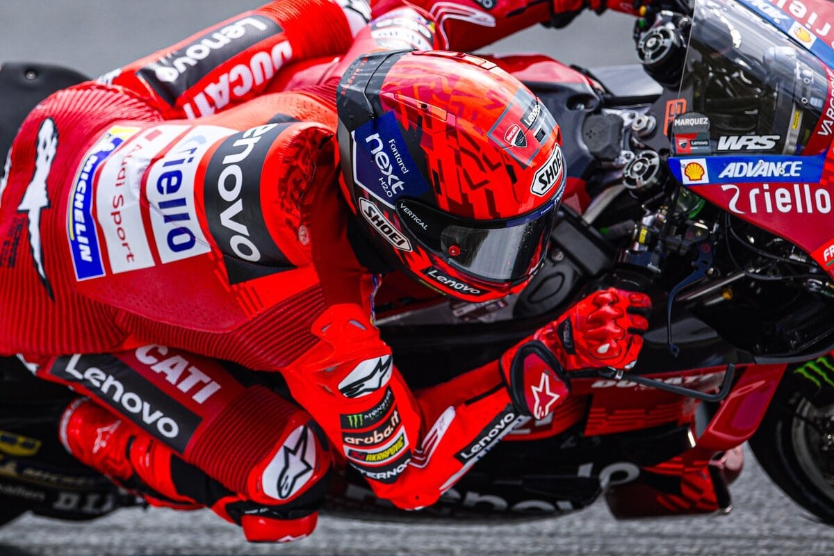 Motociclista professionista in gara di MotoGP, pilota in corsa su moto da gara rossa, atleta di alta velocità, immagine di competizione motoristica, circuito automobilistico, emozioni di gara, eventi sportivi motociclistici, quotidiano motori, motori e corse, news motori 2023, sport motoristico, passione per le due ruote.