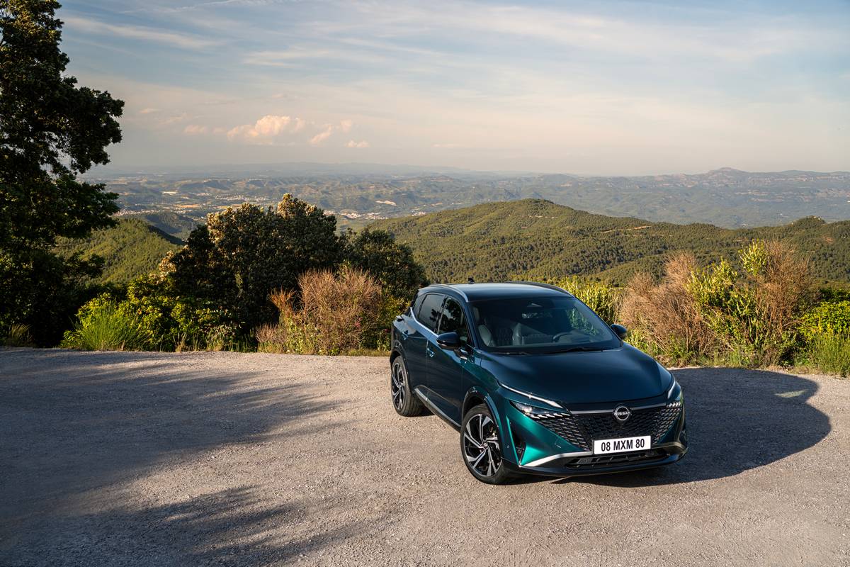 Nissan Qashqai e-POWER verde metallizzato parcheggiata in un punto panoramico di montagna.