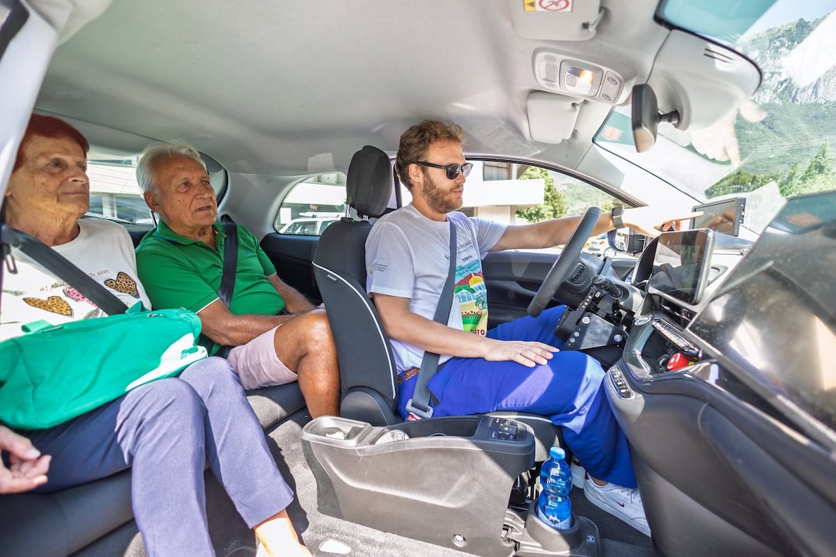 Interni della Fiat 500e del Politecnico di Milano con passeggeri anziani e conducente al volante