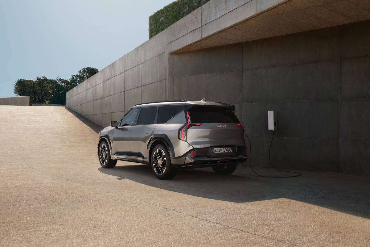 Kia EV9 GT grigio in ricarica, SUV elettrico, vista posteriore, design futuristico.