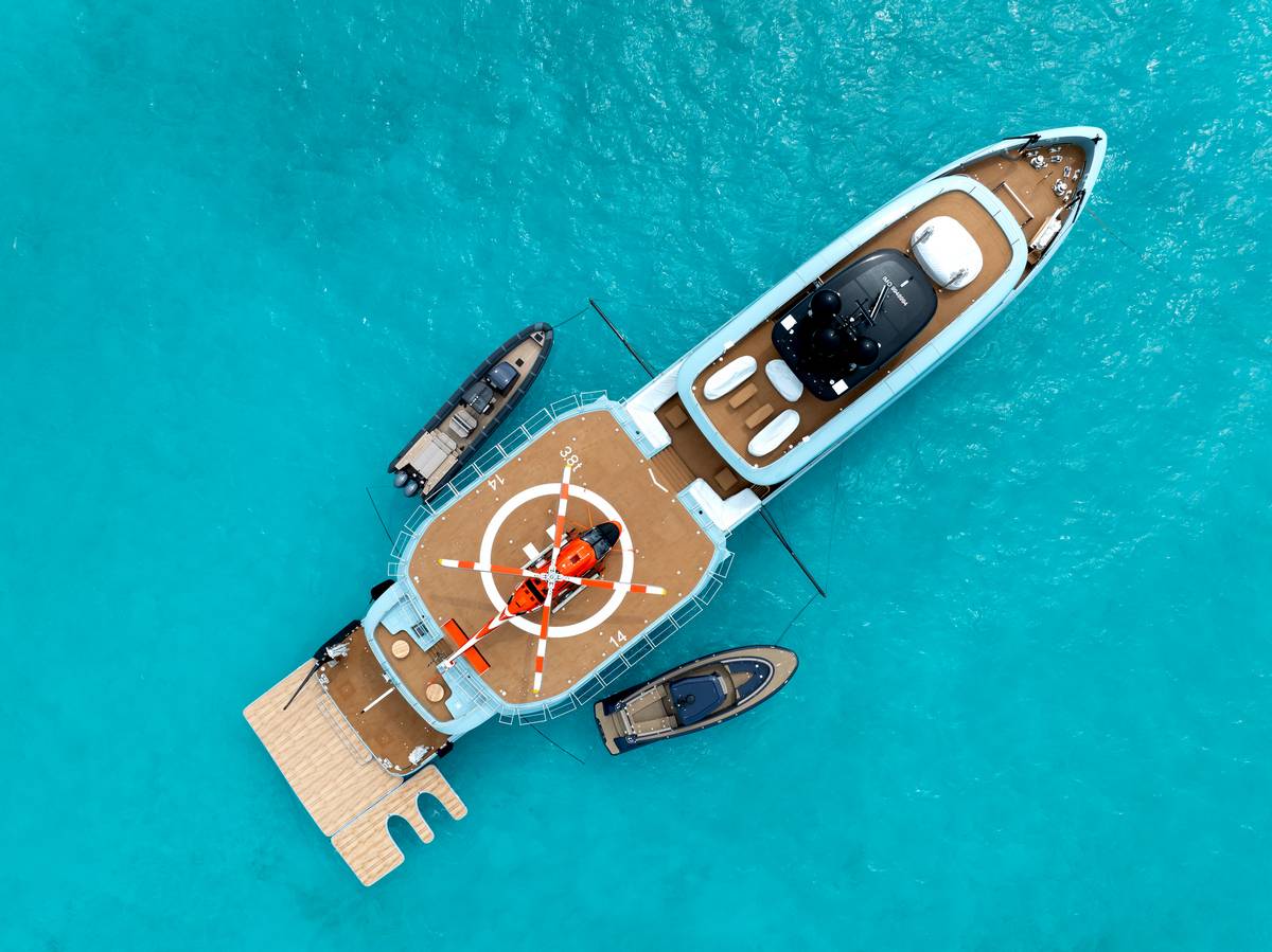 Vista aerea di Limerence Alia Yachts con elicottero rosso sul ponte e tre tender ormeggiati in acque turchesi