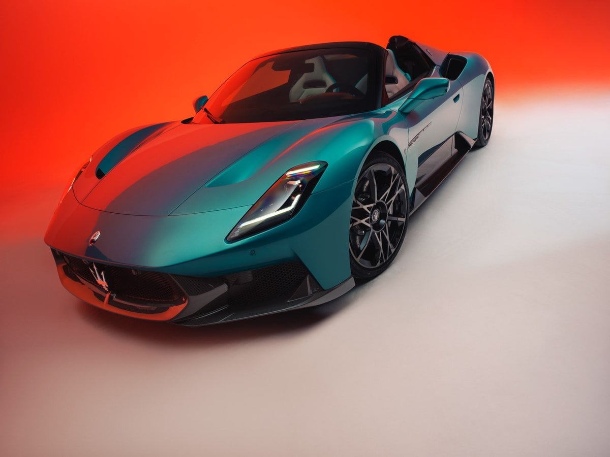 Maserati MCPURA Cielo azzurra vista frontale a 3/4, roadster sportiva a cielo aperto su sfondo arancione brillante