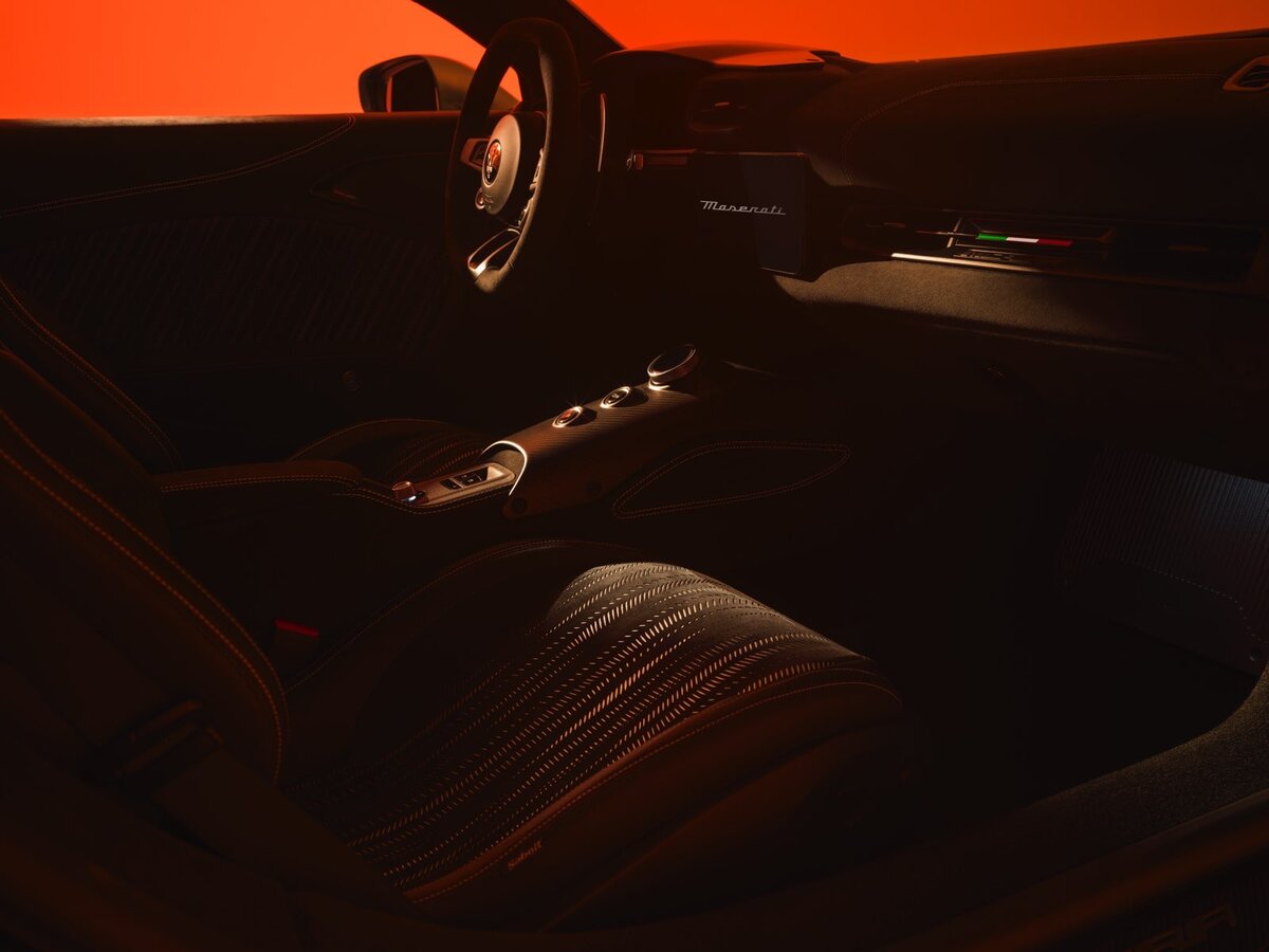 Interni Maserati MCPURA con sedili sportivi in pelle nera e cuciture a contrasto, console centrale e volante con logo Tridente