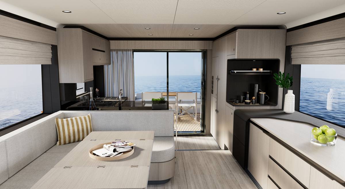 Salone open space Sirena 60 con cucina, tavolo e divano chiaro vista mare