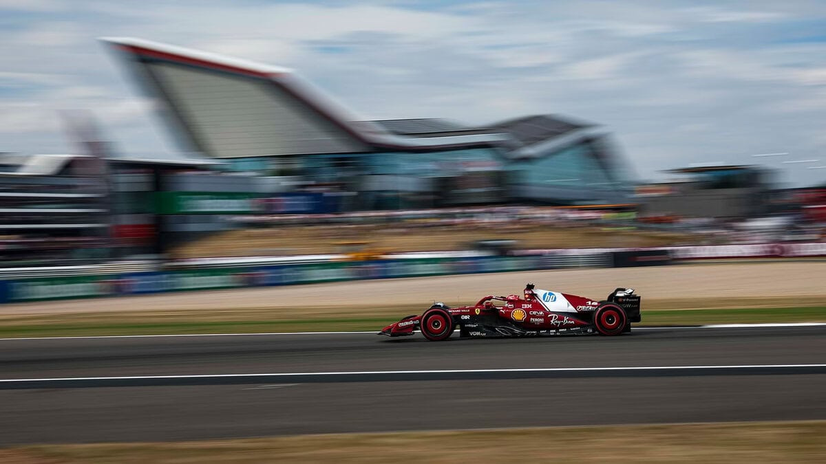 Ferrari SF-24 rossa in azione laterale, guidata da Charles Leclerc durante un GP di Formula 1 2025.