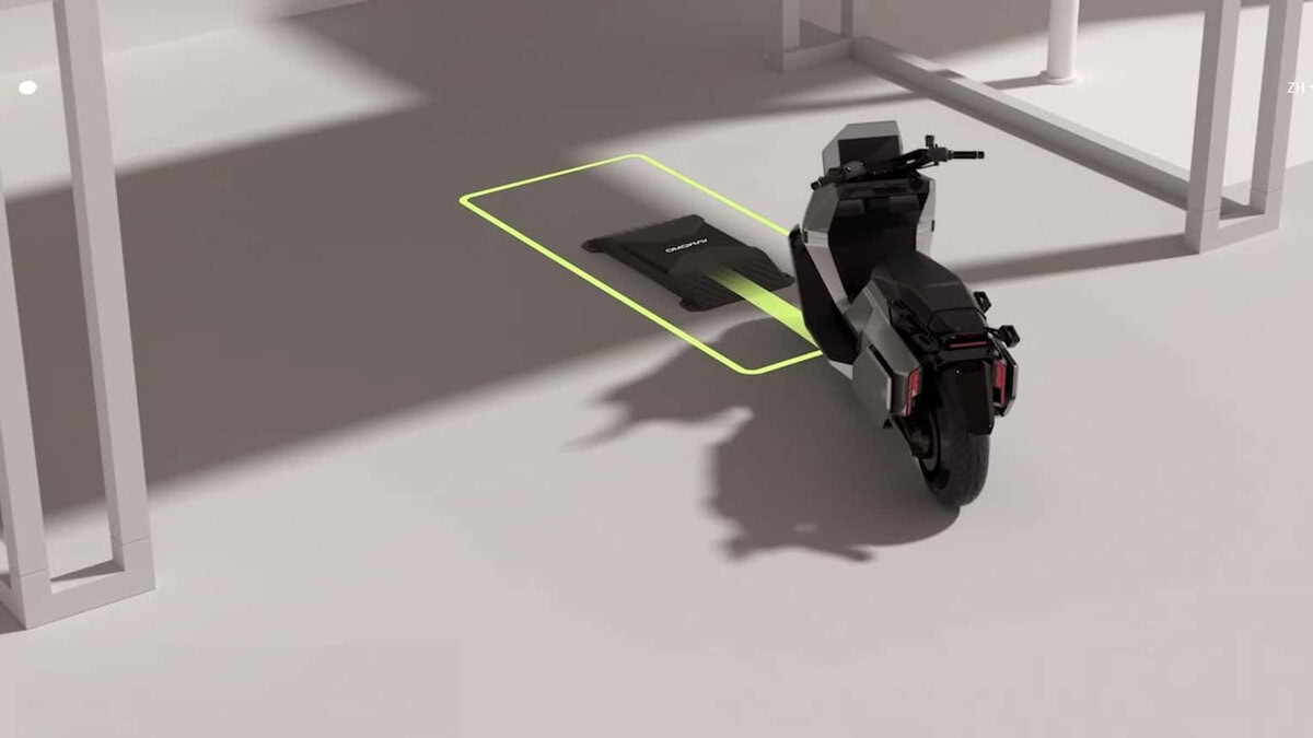  Scooter elettrico OMO X visto da dietro su base per ricarica wireless a induzione, in ambiente chiaro e minimalista