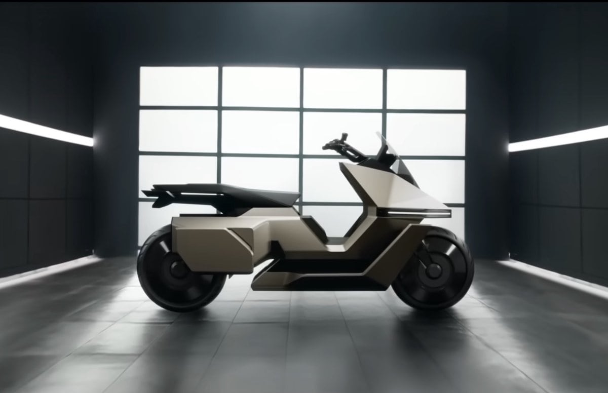 Scooter elettrico OMO X color sabbia visto di profilo in uno showroom moderno, design geometrico e linee futuristiche