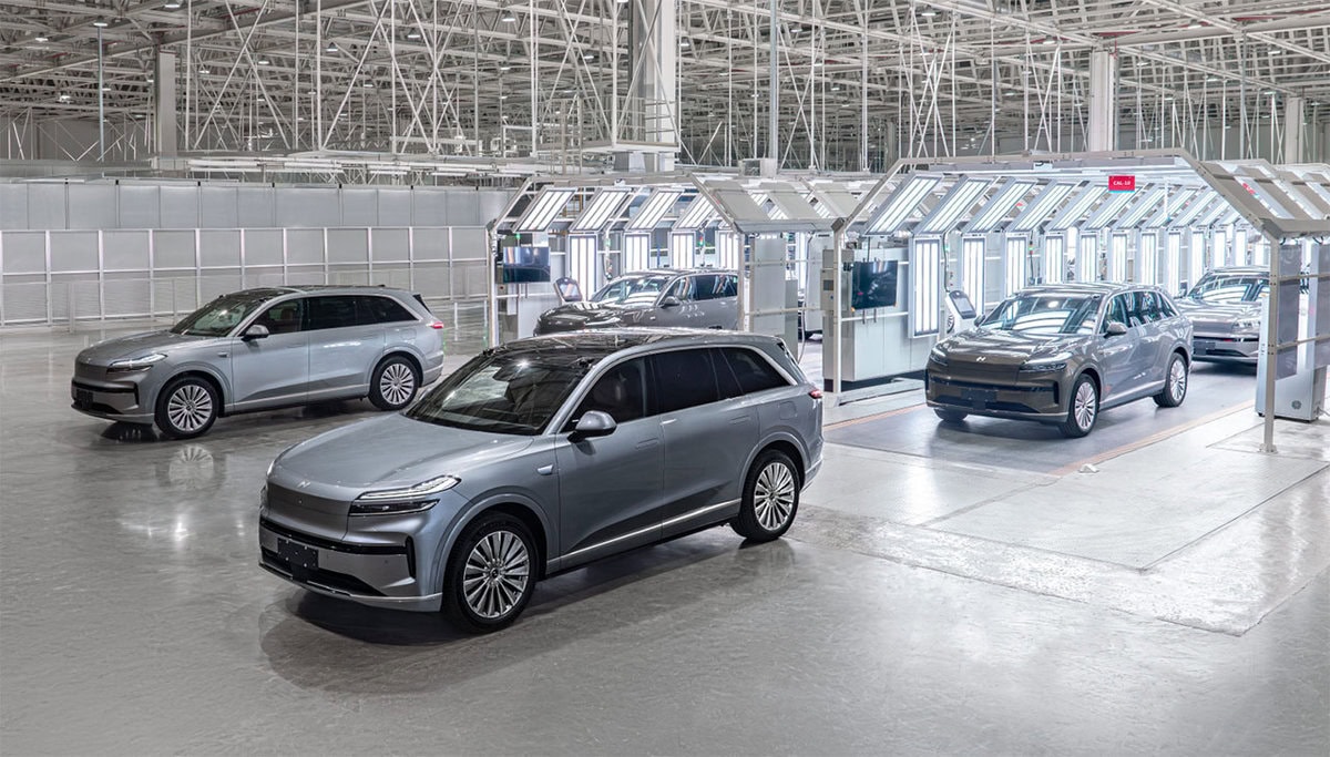 SUV elettrici Onvo L60 grigi all’interno della linea di produzione, fotografati in fabbrica sotto luci industriali durante il controllo qualità.