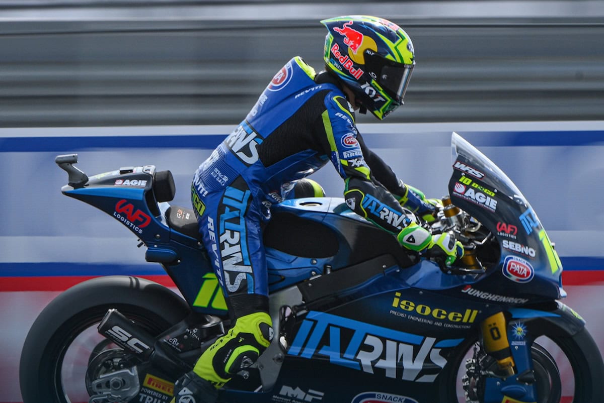 Diogo Moreira in Moto2 con casco con visiera, abbigliamento tecnico da corsa, branding di sponsor e impianto di bellezza aerodinamico.