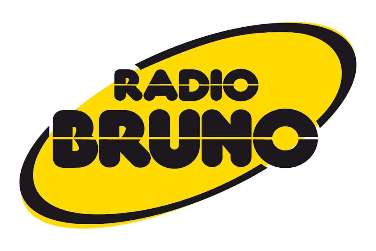 Logo di Radio Bruno con scritta nera su sfondo giallo ovale inclinato.