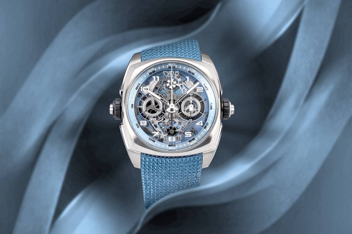 Orologio da polso di lusso con cassa in acciaio, quadrante scheletrato e cinturino in tessuto blu, design innovativo e dettagli precisi.