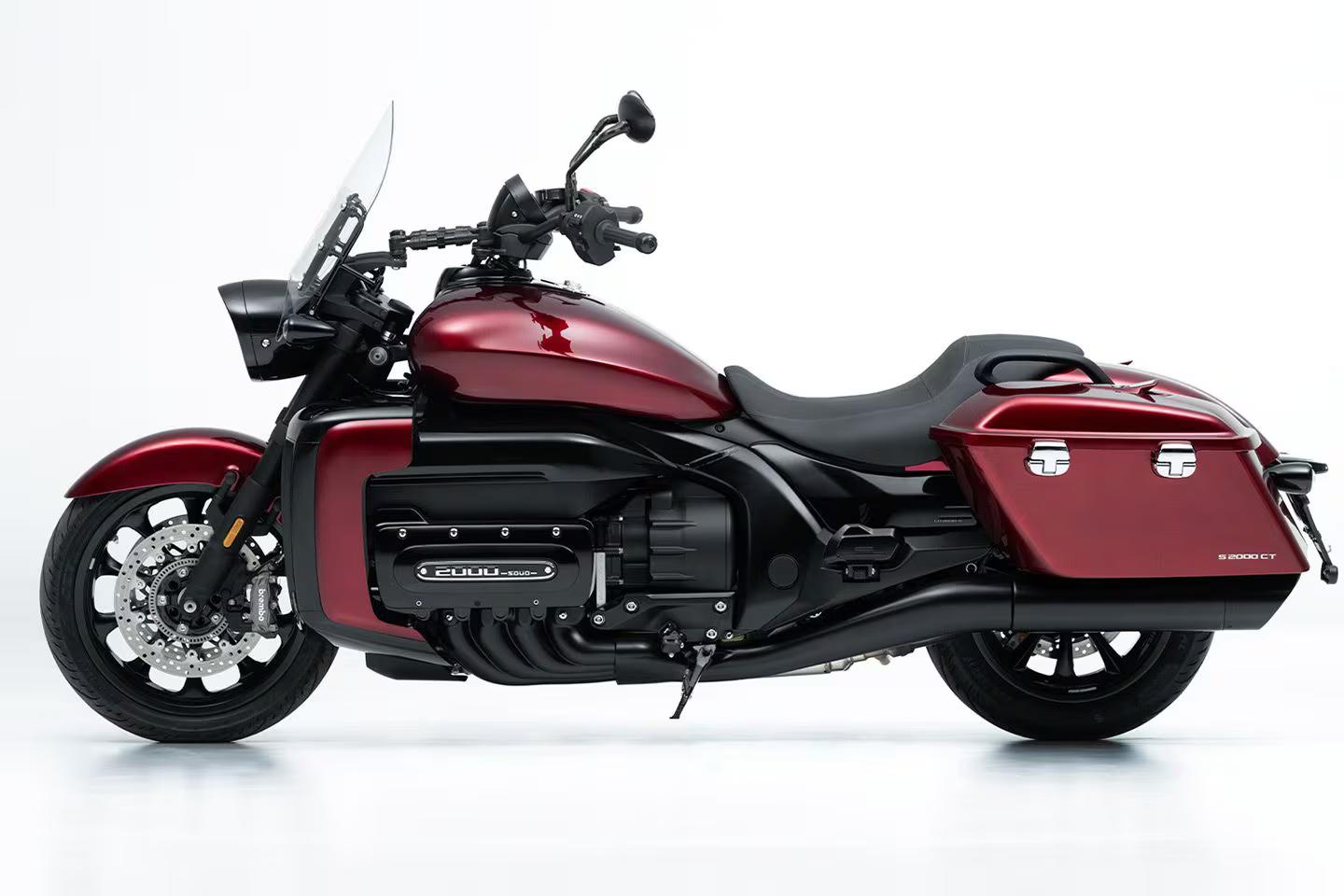 Moto cruiser Souo S2000 CT rossa vista di profilo su sfondo bianco, con borse laterali rigide, parabrezza basso e motore da 2000 cc a sei cilindri evidenziato sul lato.