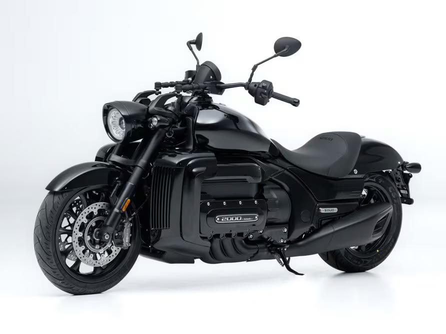 Moto cruiser Souo S2000 CT completamente nera su sfondo bianco, con design muscoloso, scarico nero opaco e motore 2000 cc a sei cilindri evidenziato lateralmente.
