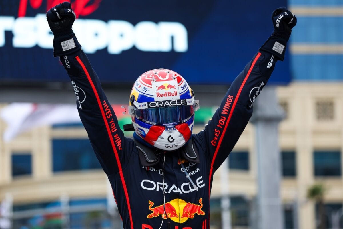 Verstappen festeggia vittoria in Formula 1 con casco Red Bull e tuta sponsor Oracle a Singapore.