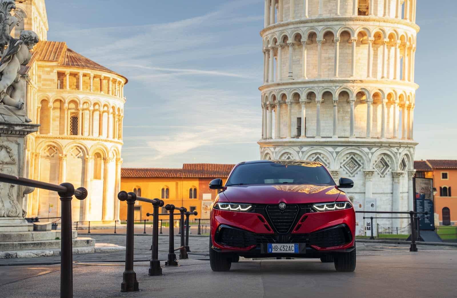 Auto Alfa Romeo Tonale MY 2026 giuda in Piazza dei Miracoli con la Torre Pendente di Pisa al tramonto.