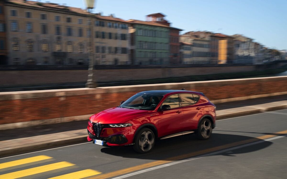 Alfa Romeo Tonale MY 2026 sportiva moderna nera con dettagli rossi in movimento sulla strada urbana, design aerodinamico, dinamica di guida, automobili di lusso, tecnologia automotive avanzata.